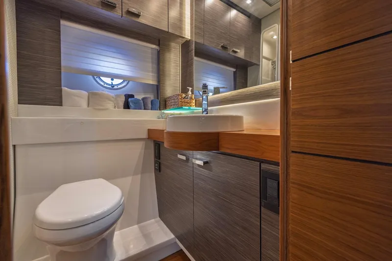 Slide: The Image of Luxurious bathroom in 2020 Tiara Yachts C53 Coupe with modern fixtures and wood accents. - 64