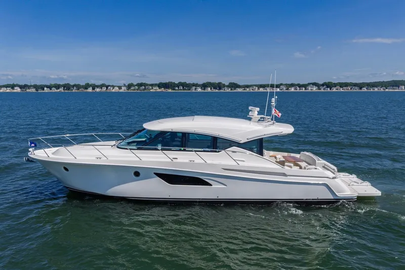 Slide: The Image of 2020 Tiara Yachts C53 Coupe cruising on open water under clear skies. - 8