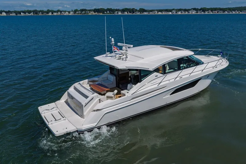 Slide: The Image of 2020 Tiara Yachts C53 Coupe cruising on open water, showcasing sleek design and luxury. - 9