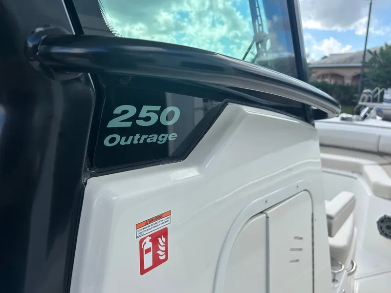 Slide: The Image of Close-up of the Boston Whaler 250 Outrage with a shiny railing and fire extinguisher sticker. - 18