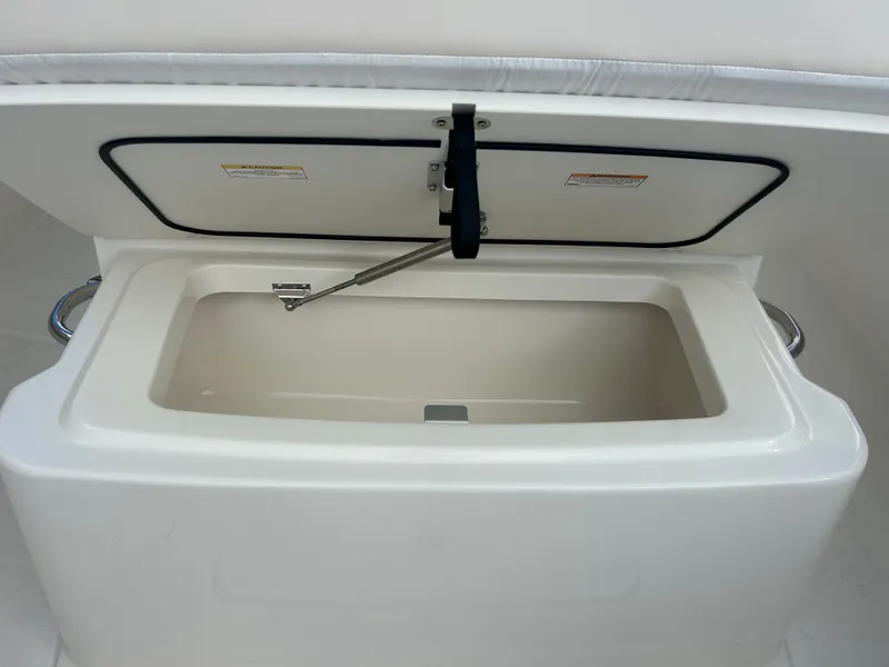 Slide: The Image of An open storage compartment on a Boston Whaler 250 Outrage boat, featuring a hydraulic support. - 24