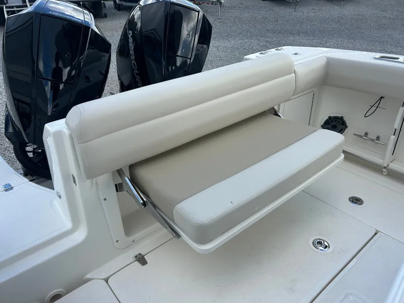 Slide: The Image of The 2027 Boston Whaler 250 Outrage features a foldable bench seat at the stern, next to two outboard engines. - 8