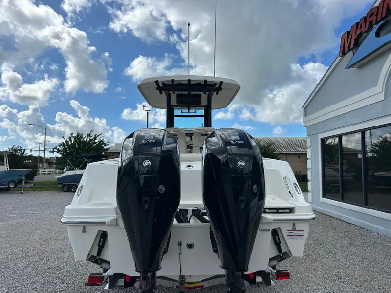 Slide: The Image of A 2027 Boston Whaler 250 Outrage with twin outboard engines, parked on gravel next to a building. - 6