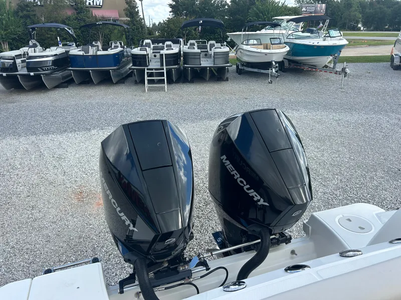 Slide: The Image of Two Mercury outboard engines are mounted on the stern of a Boston Whaler 250 Outrage, surrounded by other boats. - 17