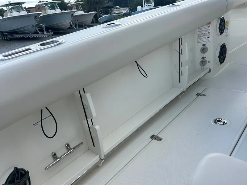 Slide: The Image of The image shows the deck of a 2027 Boston Whaler 250 Outrage with storage compartments and speakers. - 9