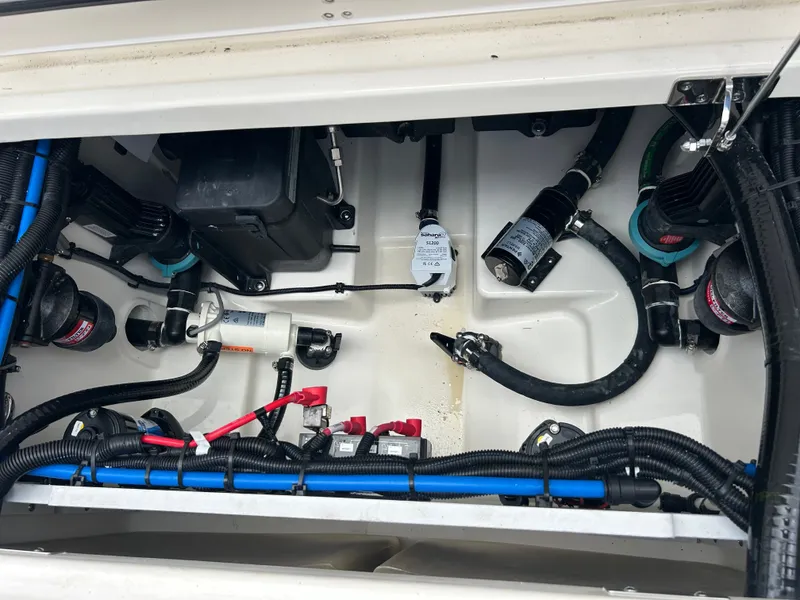 Slide: The Image of The engine compartment of a 2027 Boston Whaler 250 Outrage shows cables and hoses. - 7