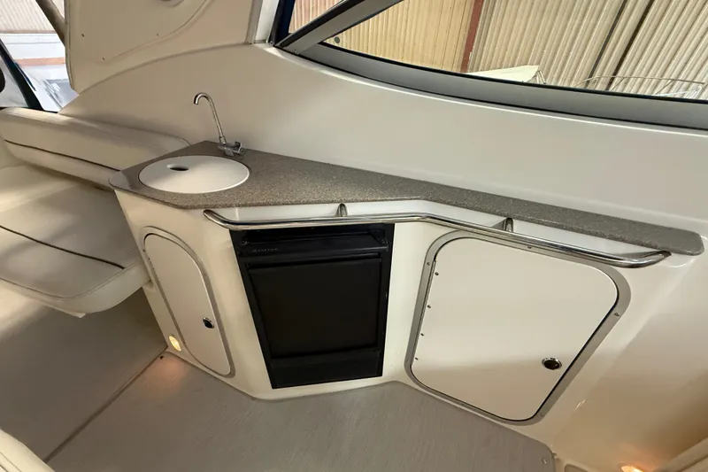 Slide: The Image of 2005 Maxum 3300 SCR boat interior with kitchenette, sink, and mini fridge. - 12