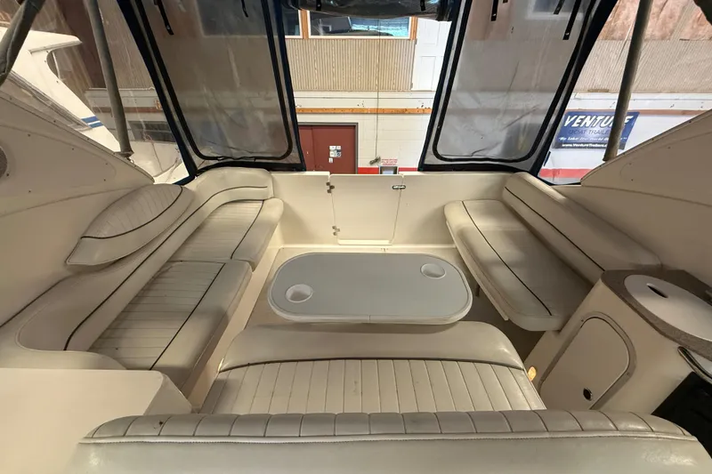Slide: The Image of 2005 Maxum 3300 SCR boat interior with spacious seating and table setup. - 13