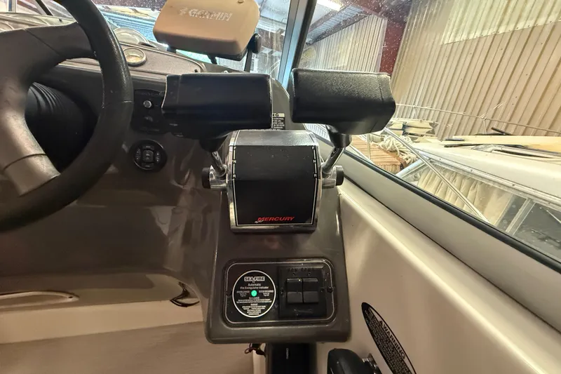 Slide: The Image of 2005 Maxum 3300 SCR boat cockpit with Mercury throttle controls and steering wheel. - 23