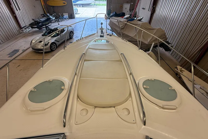 Slide: The Image of 2005 Maxum 3300 SCR boat in storage, with cars and equipment nearby. - 26