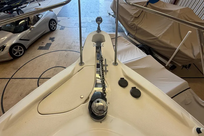 Slide: The Image of Bow view of 2005 Maxum 3300 SCR yacht in storage, with cars nearby. - 27