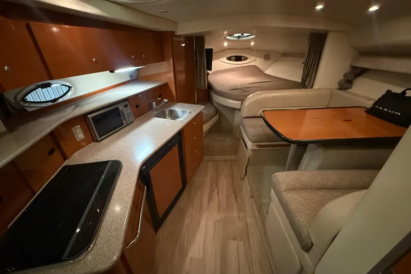 Slide: The Image of 2005 Maxum 3300 SCR yacht interior with kitchen, dining area, and sleeping quarters. - 30