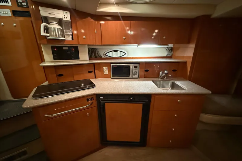 Slide: The Image of 2005 Maxum 3300 SCR yacht kitchen with microwave, sink, and stove. - 34