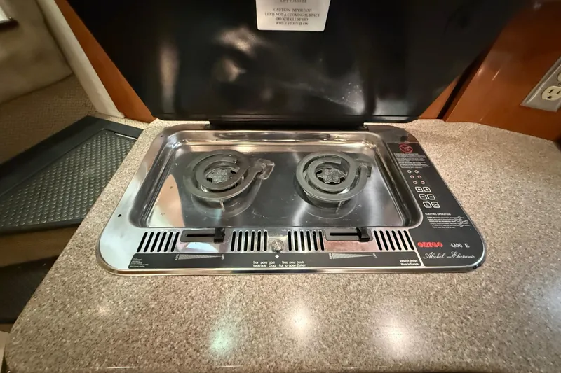 Slide: The Image of 2005 Maxum 3300 SCR boat kitchen with a two-burner stove on a granite countertop. - 37