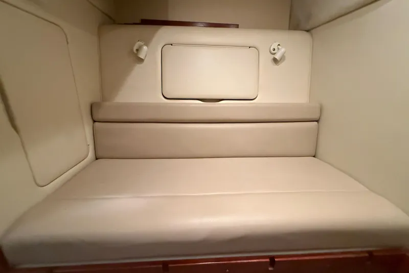 Slide: The Image of 2005 Maxum 3300 SCR cabin interior with beige seating and storage compartment. - 49