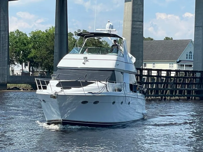 Slide: The Image of 1998 Carver 530 Voyager Pilothouse yacht cruising under a bridge on a sunny day. - 4