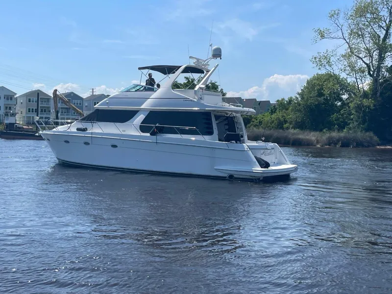 Slide: The Image of 1998 Carver 530 Voyager Pilothouse yacht cruising on a calm river. - 6