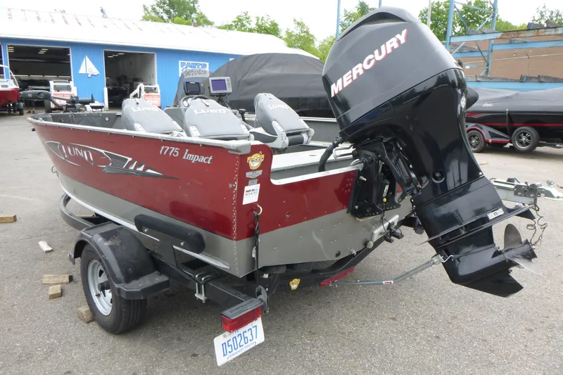 Slide: The Image of 2012 Lund 1775 Impact boat with Mercury outboard motor in a marina setting. - 3