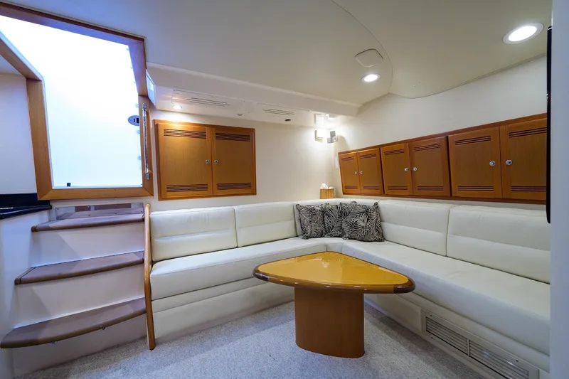 Slide: The Image of Interior of a 2005 Cabo Express yacht with white sofa and wooden cabinets. - 2