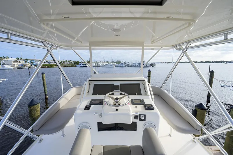 Slide: The Image of Helm of a 2005 Cabo Express yacht in the harbor. - 26