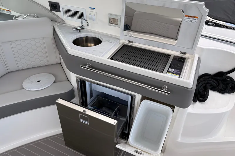 Slide: The Image of 2026 Sea Ray Sundancer 320 boat kitchenette with sink, grill, and storage. - 5