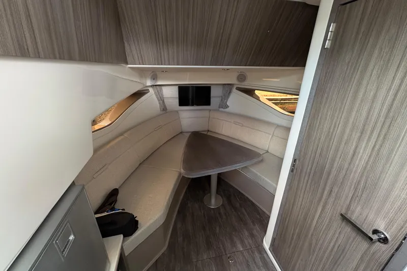 Slide: The Image of Interior of 2026 Sea Ray Sundancer 320, featuring a cozy seating area with a wooden table. - 14