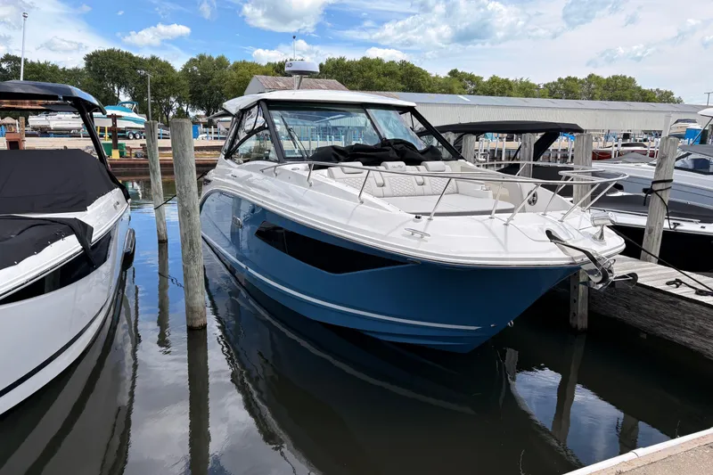 The Image of 2026 Sea Ray Sundancer 320 docked at marina, featuring sleek blue and white design. - 0