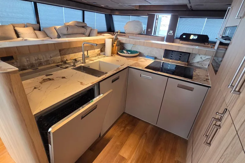 Slide: The Image of Modern yacht kitchen with marble countertops, sleek appliances, and wooden cabinetry, Moon 60 model, 2025. - 10