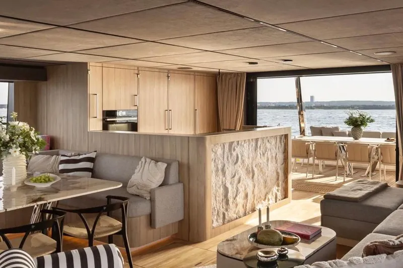 Slide: The Image of Luxurious 2025 Moon 60 yacht interior with modern kitchen, dining area, and scenic ocean view. - 13