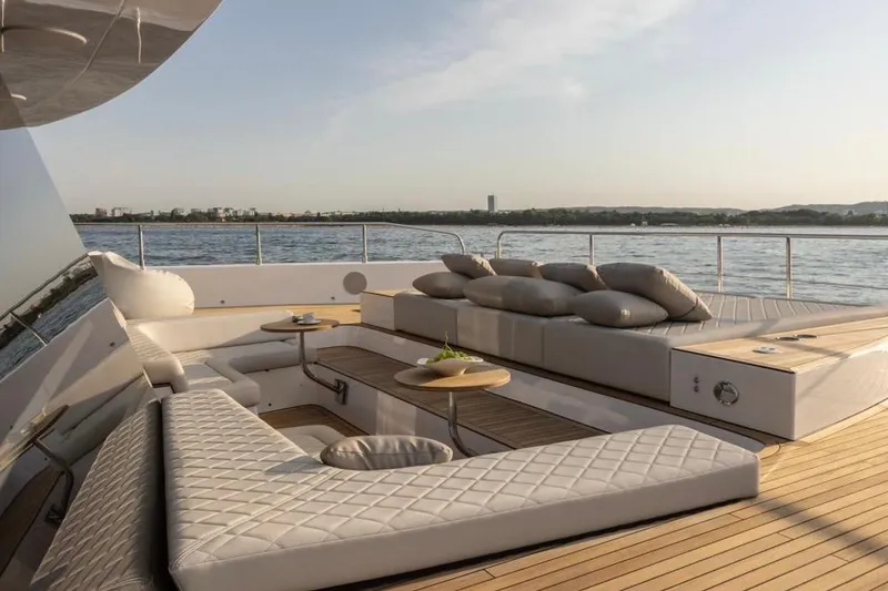 Slide: The Image of Luxurious Moon 60 yacht deck with plush seating, overlooking serene waters, 2025 model. - 21