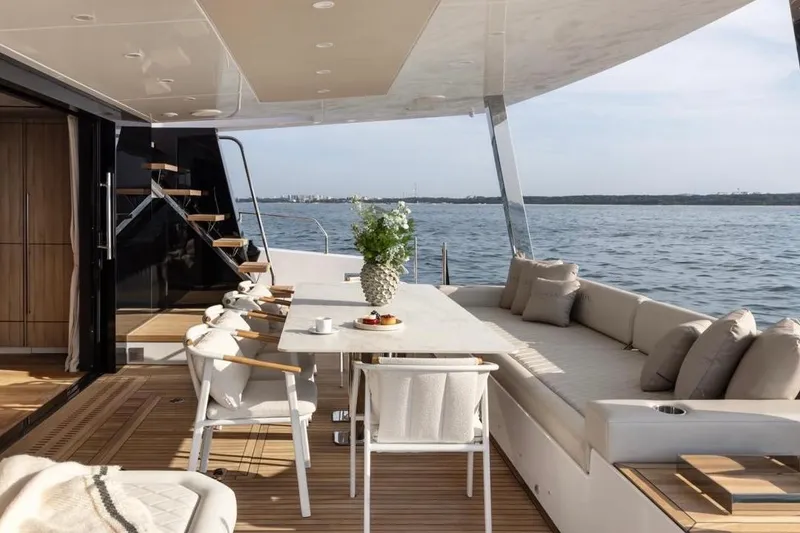 Slide: The Image of Luxurious Moon 60 yacht deck with dining area, elegant seating, and ocean view, 2025 model. - 25