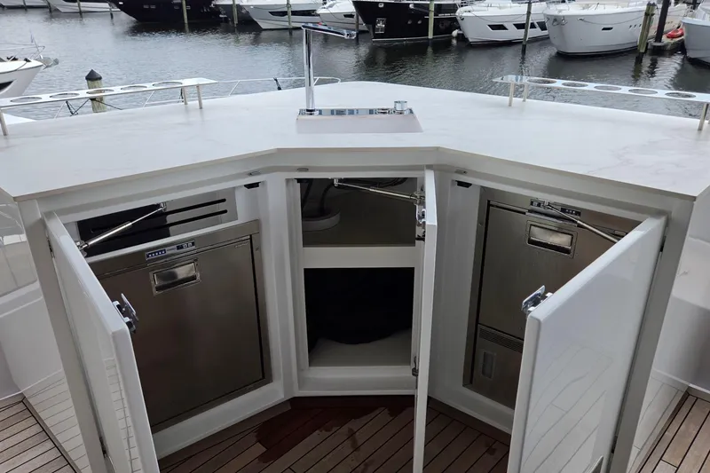 Slide: The Image of Luxury yacht kitchen with open cabinets, stainless steel appliances, and marina view. Moon 60, 2025 model. - 28