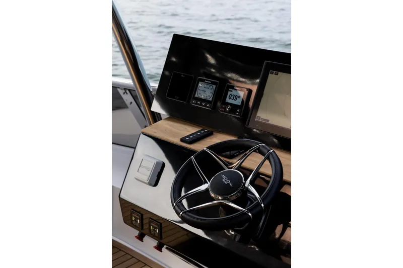 Slide: The Image of Steering console of 2025 Moon 60 yacht with navigation instruments and controls. - 31