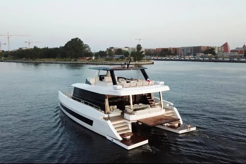 Slide: The Image of Luxurious 2025 Moon 60 yacht cruising on calm waters near a cityscape. - 4
