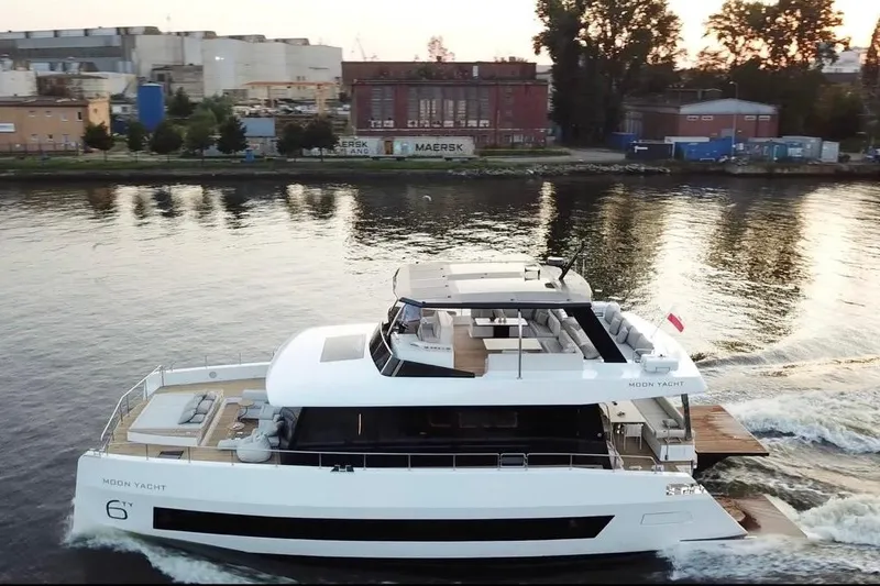 Slide: The Image of Luxurious 2025 Moon 60 yacht cruising on a serene river near industrial buildings. - 5