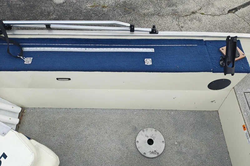 Slide: The Image of 1999 LOWE BOATS SEA NYMPH V-148SC interior with blue carpet and fishing rod holder. - 12