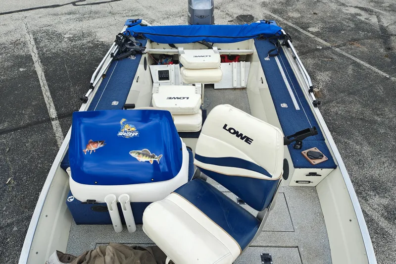 Slide: The Image of 1999 LOWE BOATS SEA NYMPH V-148SC interior with blue and white seating, fishing gear. - 9