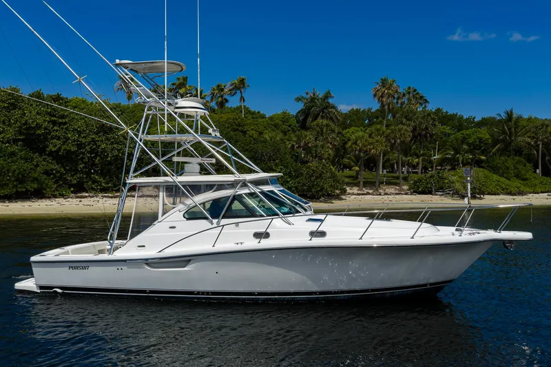 The Image of 2004 Pursuit 3800 Express boat on calm water near a tropical shoreline. - 0