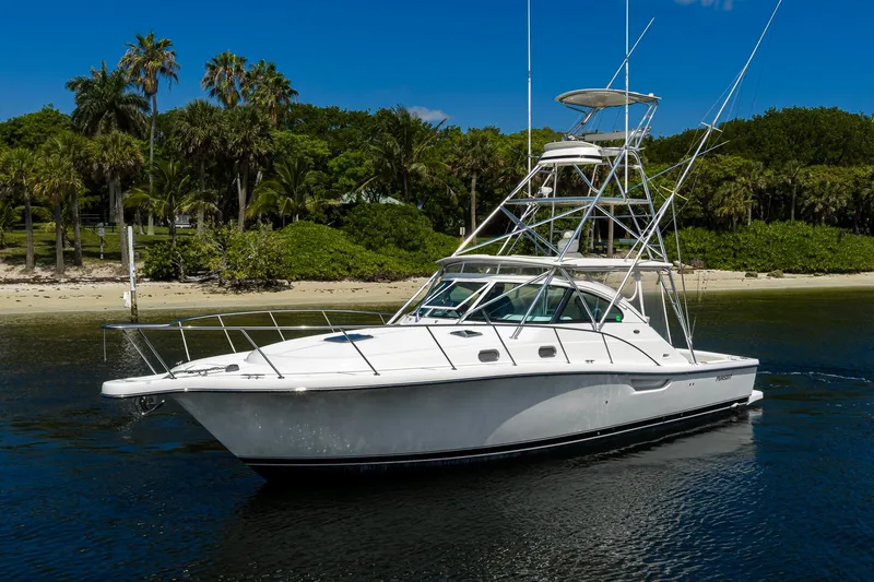Slide: The Image of 2004 Pursuit 3800 Express yacht cruising near a tropical shoreline with palm trees. - 11