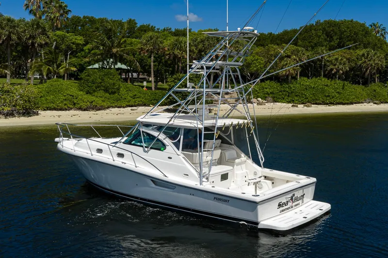 Slide: The Image of 2004 Pursuit 3800 Express boat cruising near a tropical shoreline. - 12
