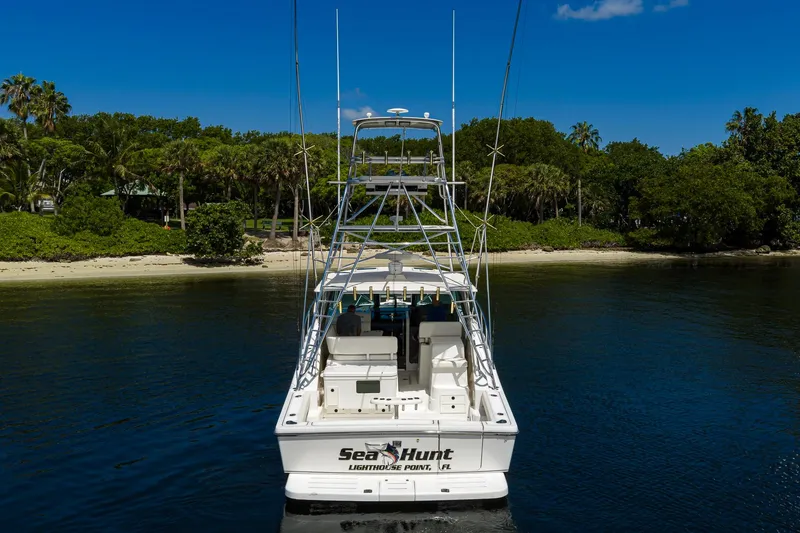 Slide: The Image of 2004 Pursuit 3800 Express boat docked near lush green shoreline. - 14