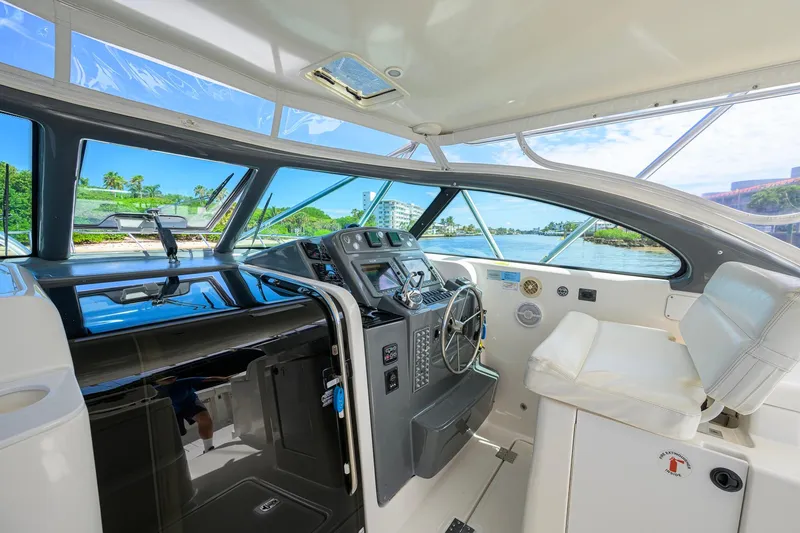 Slide: The Image of Interior view of 2004 Pursuit 3800 Express yacht cockpit with steering wheel and navigation controls. - 19