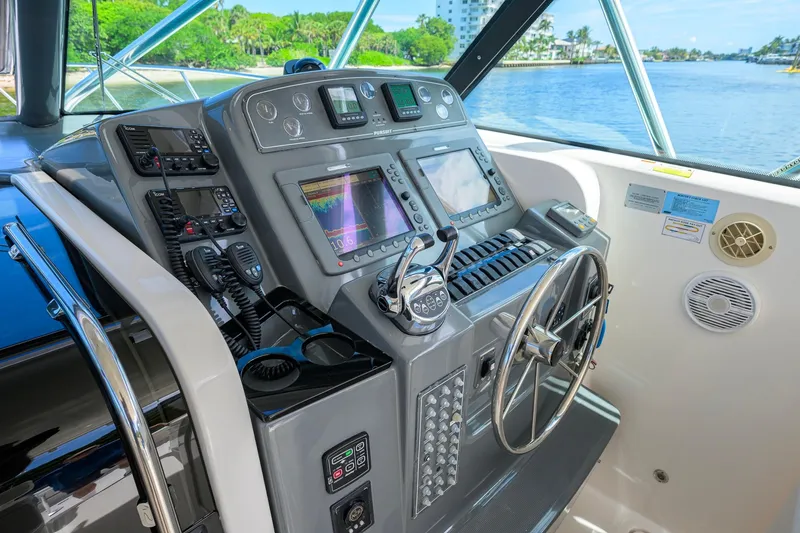 Slide: The Image of Control panel of a 2004 Pursuit 3800 Express boat with navigation equipment and steering wheel. - 20