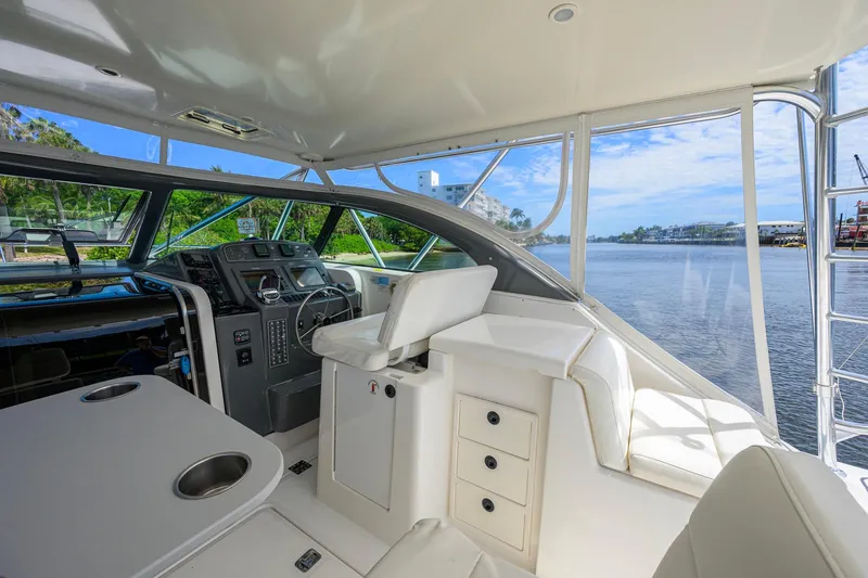 Slide: The Image of 2004 Pursuit 3800 Express yacht interior with helm, seating, and water view. - 26