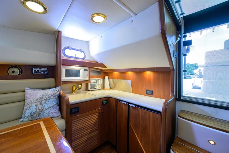 Slide: The Image of Luxurious 2004 Pursuit 3800 Express yacht interior with kitchenette and seating area. - 32