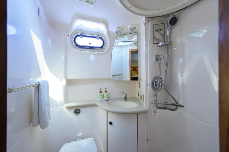 Slide: The Image of 2004 Pursuit 3800 Express yacht bathroom with shower, sink, and porthole window. - 39