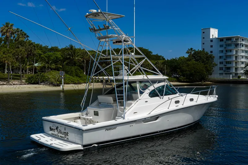 Slide: The Image of 2004 Pursuit 3800 Express boat on calm water near a tropical shoreline. - 4