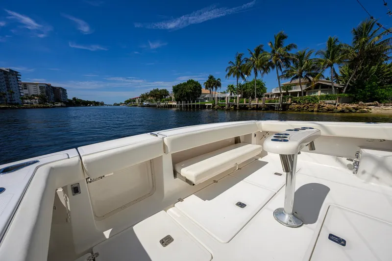 Slide: The Image of 2004 Pursuit 3800 Express boat deck with scenic waterfront view and palm trees. - 48