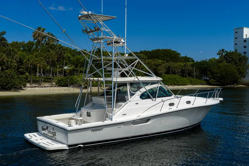 Slide: The Image of 2004 Pursuit 3800 Express boat on calm water near a tropical shoreline. - 5