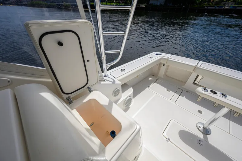Slide: The Image of 2004 Pursuit 3800 Express boat deck with open storage compartment by the water. - 53